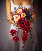 This bouquet contains flowers such as gerbera daisys, roses, dendrobium orchid stem, heather