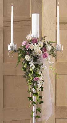 This candle arrangement contains flowers such white roses, 	pink spray roses, dendrobium orchids, white carnations, white 	lisianthus, lavender wax flower, green ivy and greens.