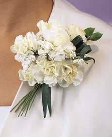 This corsage contains flowers such as white mini carnantions 	and gypsophilia.