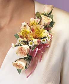 This corsage contains flowers such as peach alstroemeria, 	peach spray roses, white Monte Cassino, variegated greens and pink 	sheer ribbon. 