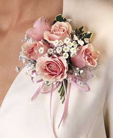 This corsage contains flowers such as five pink sweetheart 	roses, gypsophilia, variegated greens and pink ribbon string.