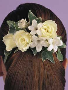 This hair piece contains flowers such as white roses, 	stephanotis and variegated ivy.