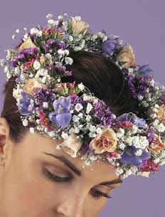 This hair piece contains flowers such as pink spray roses, 	light plue delphinium, pink kalanchoe, lavender statice and 	gypsophilia.