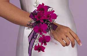 This corsage consists of purple dendrobium orchids, limonium, 	silver sheer ribbon, and purple satin ribbon.