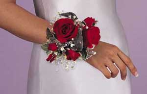 This corsage consists of 2 red roses, 1 stem or red spray 	roses, variegated ivy, gypsophilia and silver chiffon ribbon.