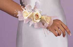 This corsage consists of 3 white roses pink chiffon ribbon and 	light blue chiffon ribbon.