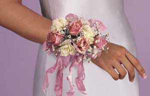 This corsage consists of one stem of pink spray roses, one 	stem of mini white carnations, one stem of gypsophilia, pink satin 	ribbon and white tulle.